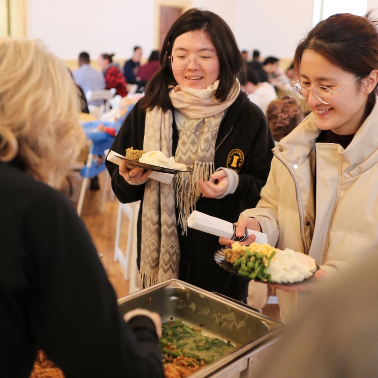 two people getting served in line at the fall break meal