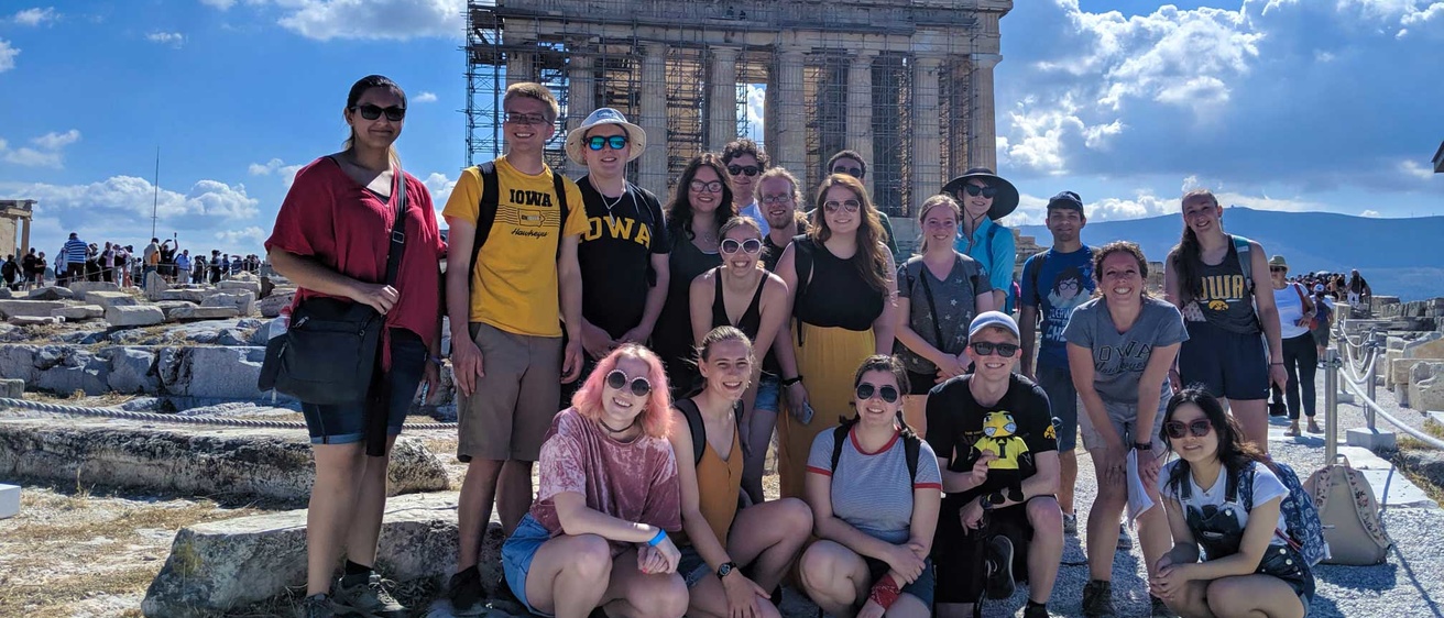 students wearing hawkeye shirts in front of Greek temple