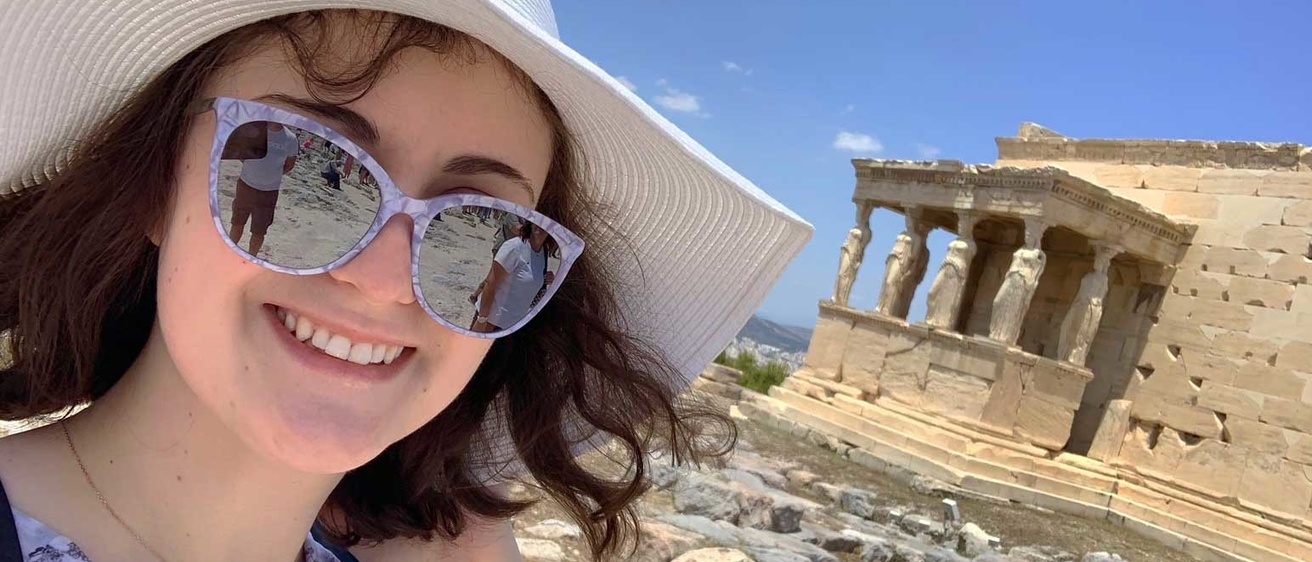 Kaitlyn Dwyer in front of an ancient building with columns in Greece