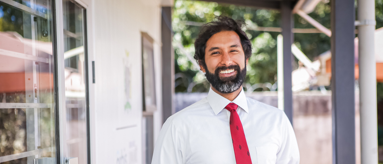 bearded professor in white shirt and red tie