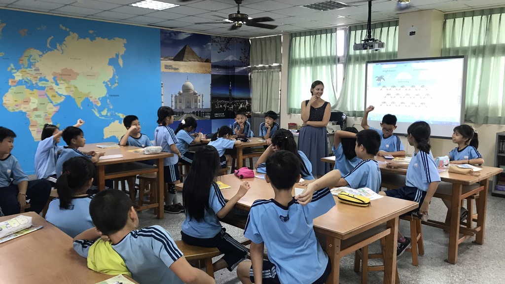 Sylvia in class with fourth graders, teaching numbers through a guessing game