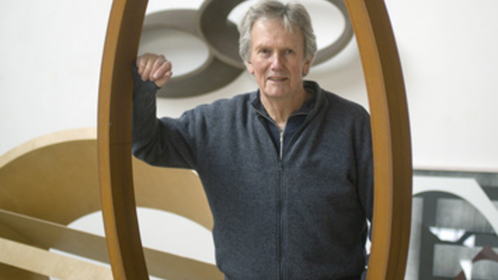 man standing with circle sculpture