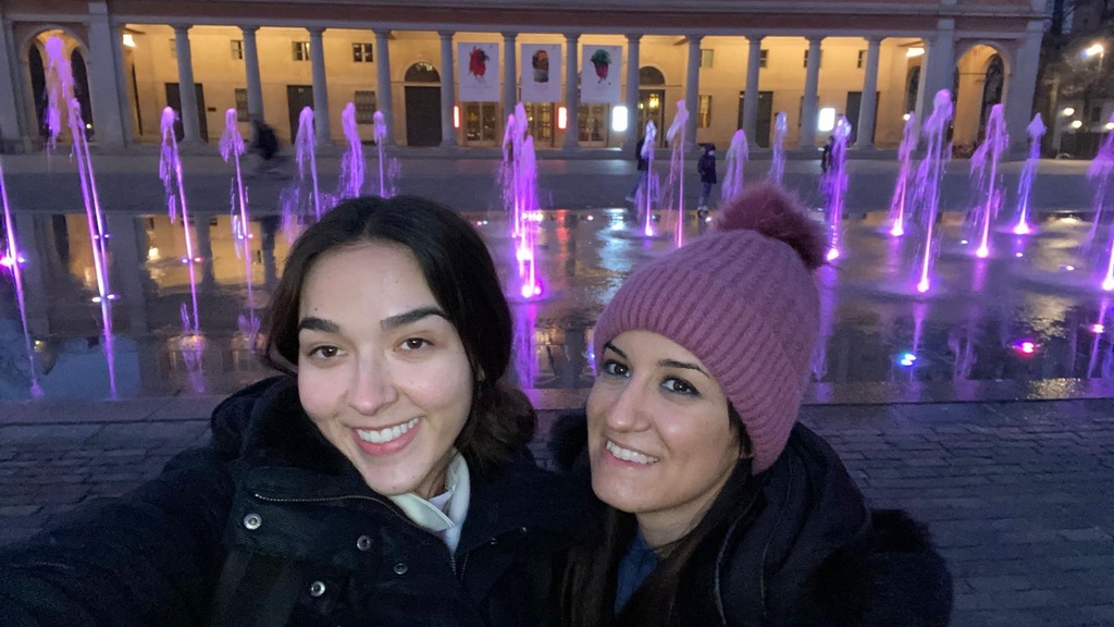 Mariana Garces Grajales with friend in front of purple lights and fountain