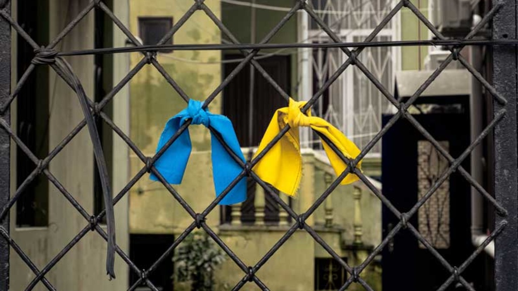 chainlink fence with blue and yellow ribbons 