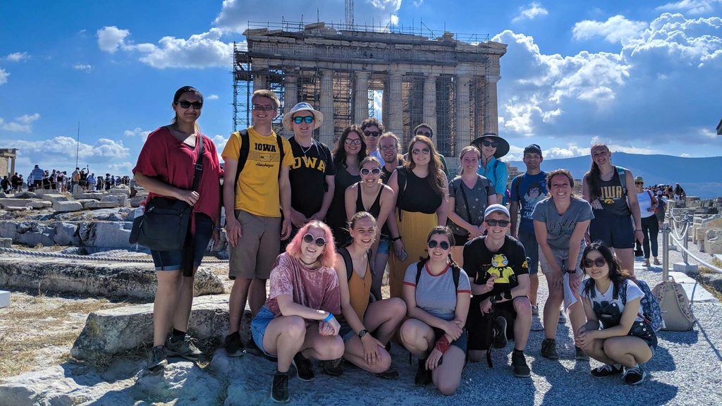students wearing hawkeye shirts in front of Greek temple