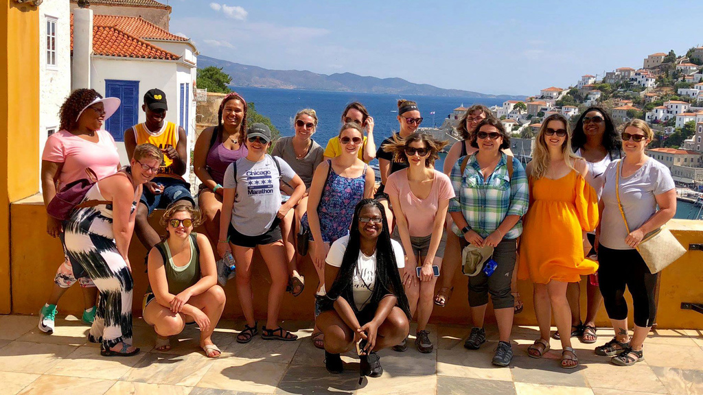 group of students with professor on landing overlooking Greece landscape
