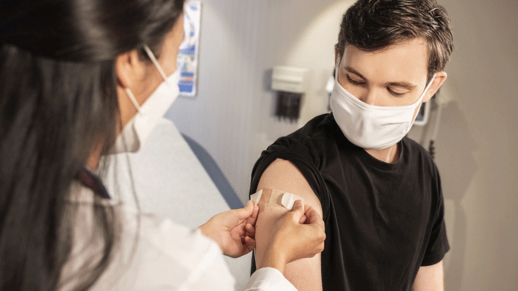 person getting Band-Aid on arm after vaccine